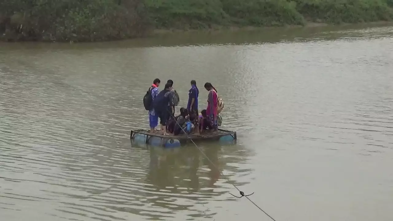 These girls have to cross the river sitting on drums