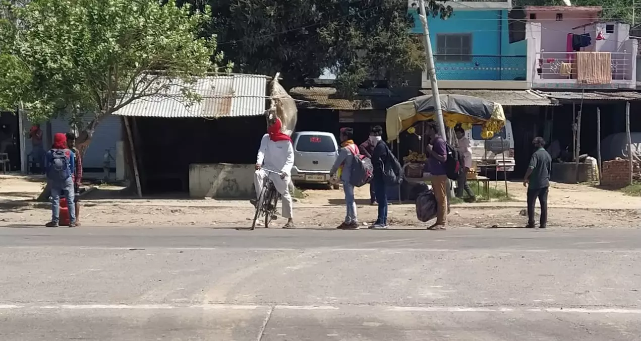 पैदल यात्रा कर रहे कुछ मजदूर जिन्हें आगे की सफर के लिए किसी साधन की तलाश है। (फोटो- दया सागर / गांव कनेक्शन)