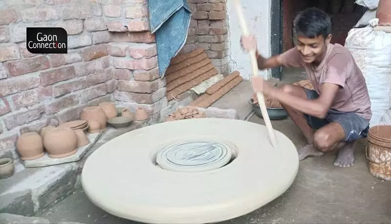 A potter making pottery in the traditional manner — without the use of electric motor. 