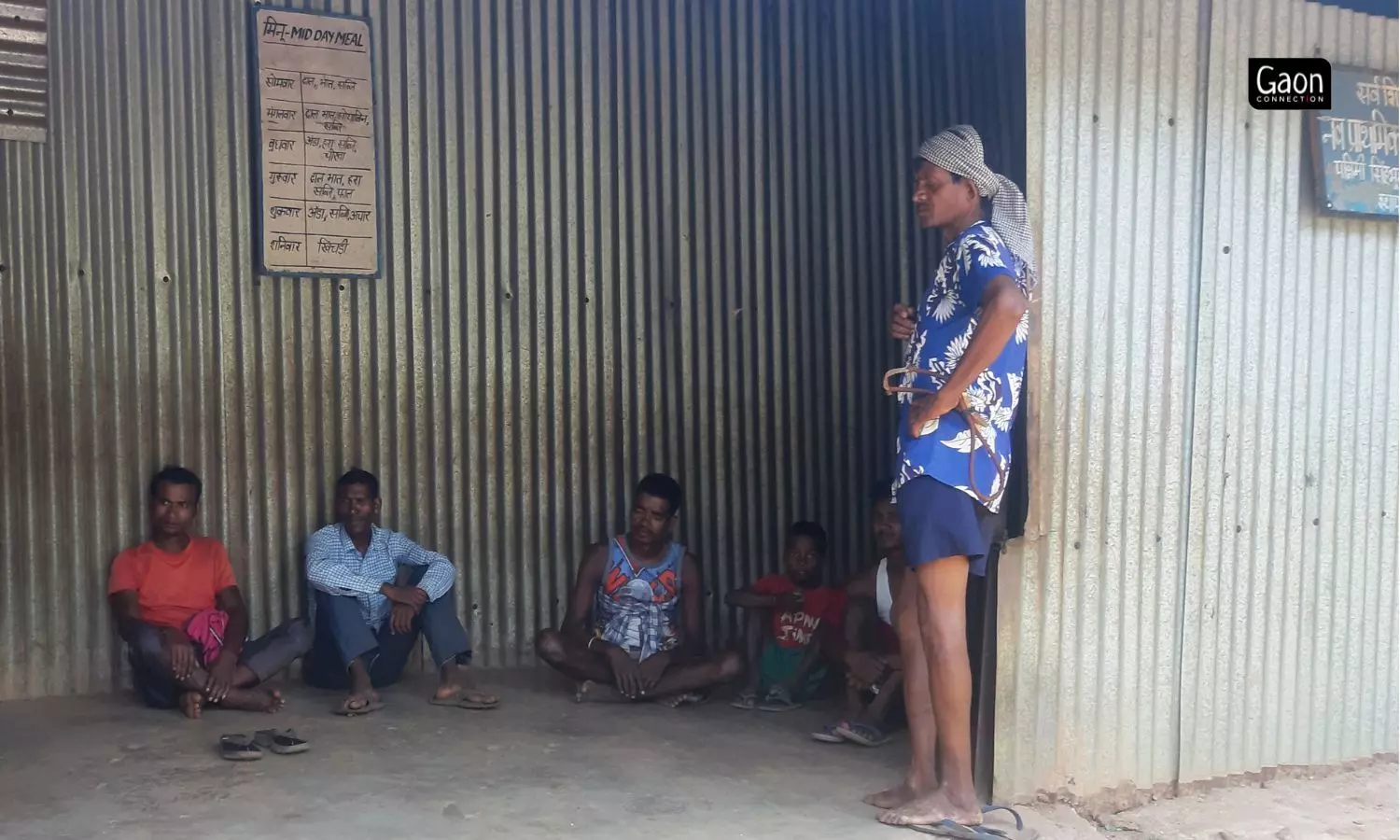 One tin room serves as a kitchen where midday meals are cooked for the children, while at a distance is another tin shack that is the toilet.