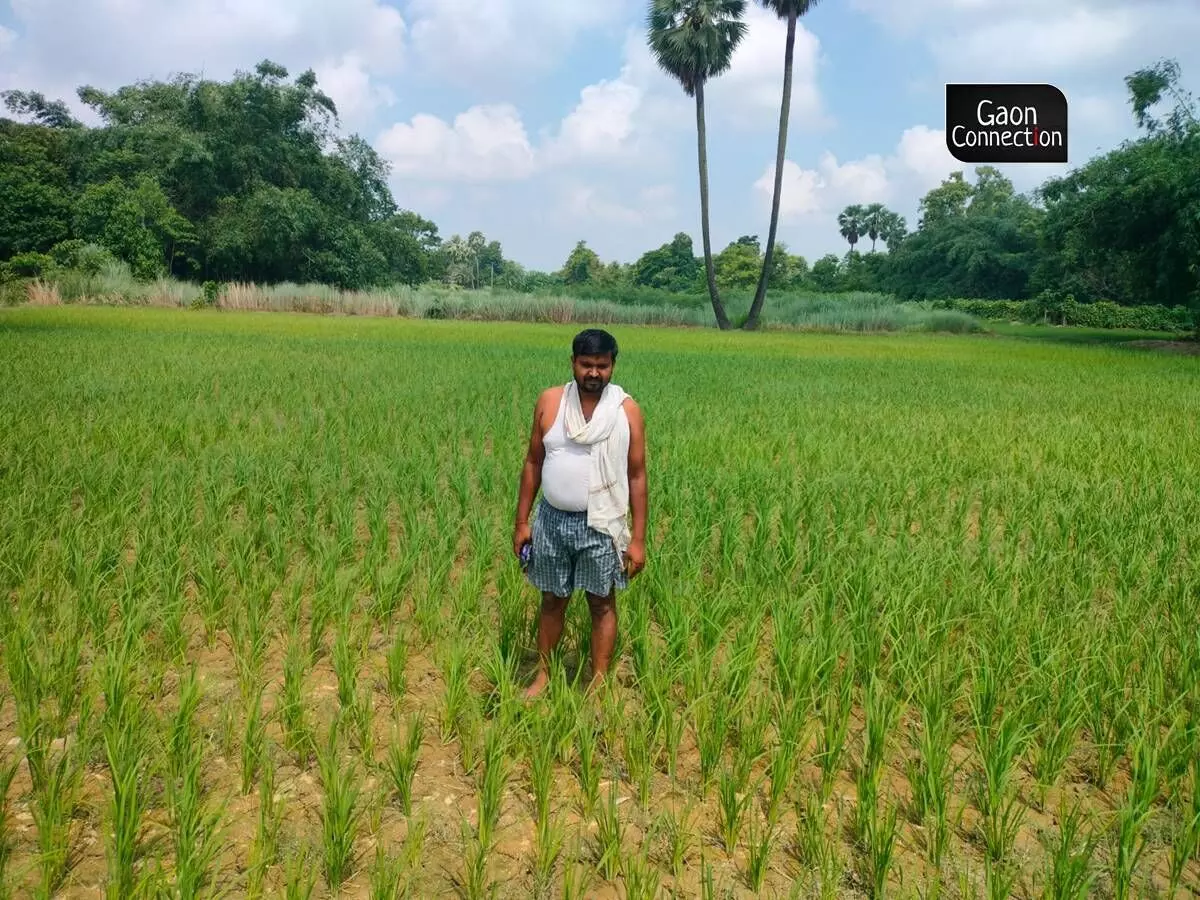 Nitish Kumar Yadav poses for a photograph in his field.