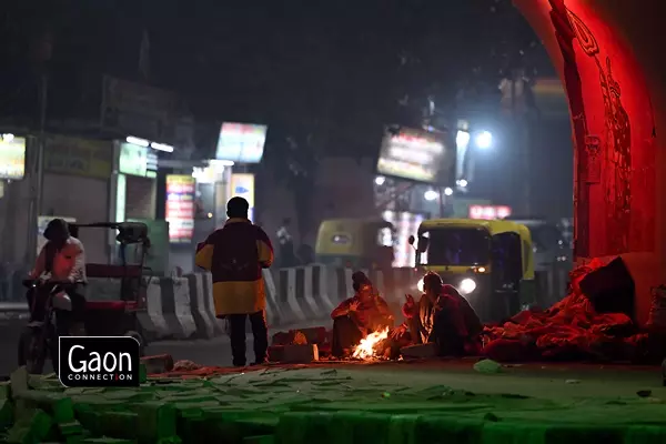 Many workers arrange a fire at roadsides to provide them with warmth to face the winter chill.